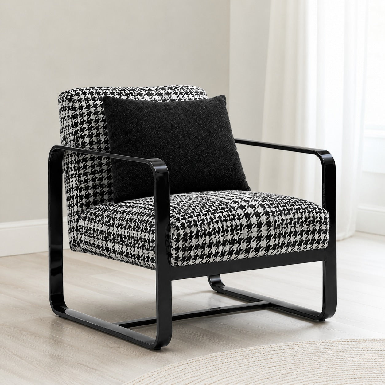 Modern armchair with houndstooth pattern and black frame in a room setting.