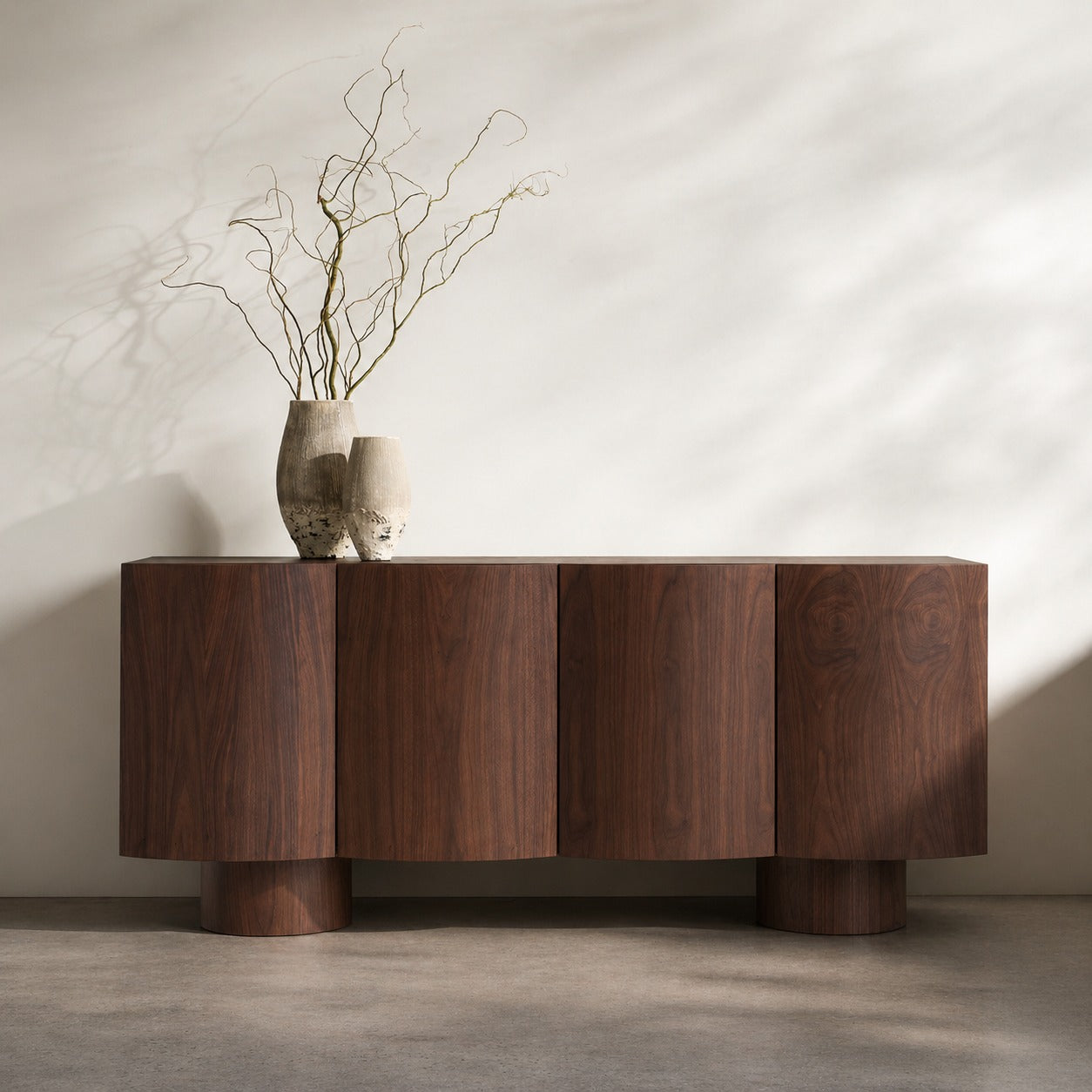 Wooden sideboard with two vases and branches on a neutral background