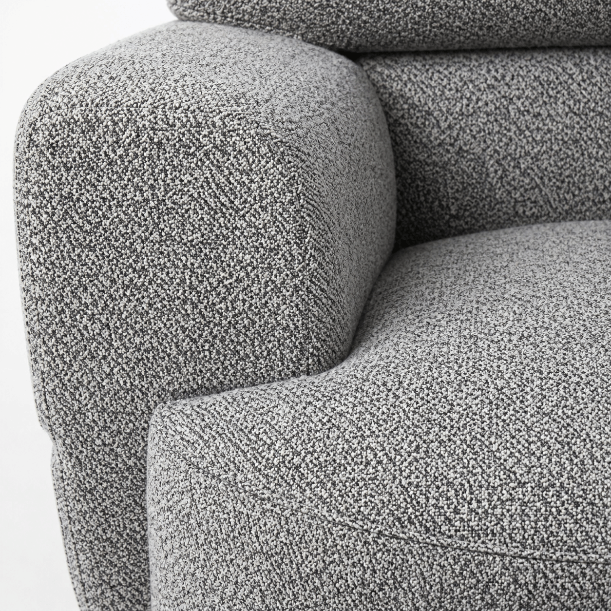 Close-up of a textured gray sofa armrest and backrest.