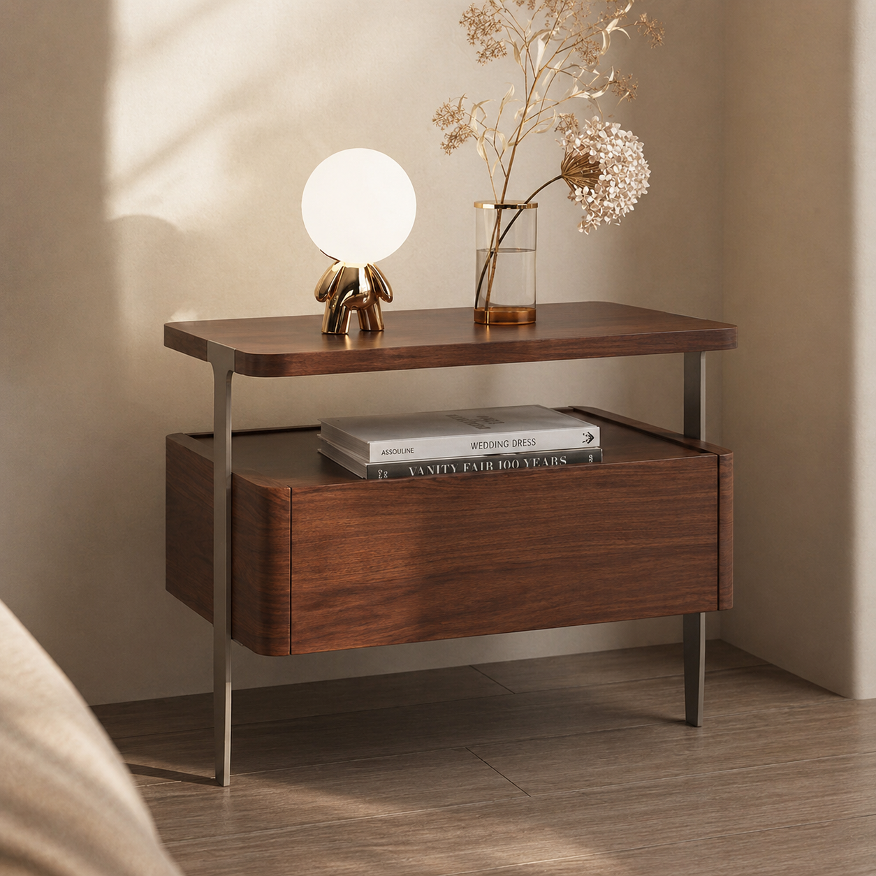 Wooden side table with a lamp, books, and decorative vase against a neutral wall.
