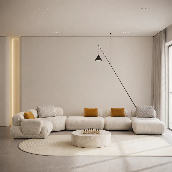Modern living room with a large white sofa and decorative pillows.
