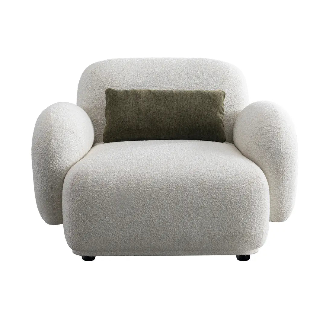 Modern armchair with a textured surface and a green pillow on a white background