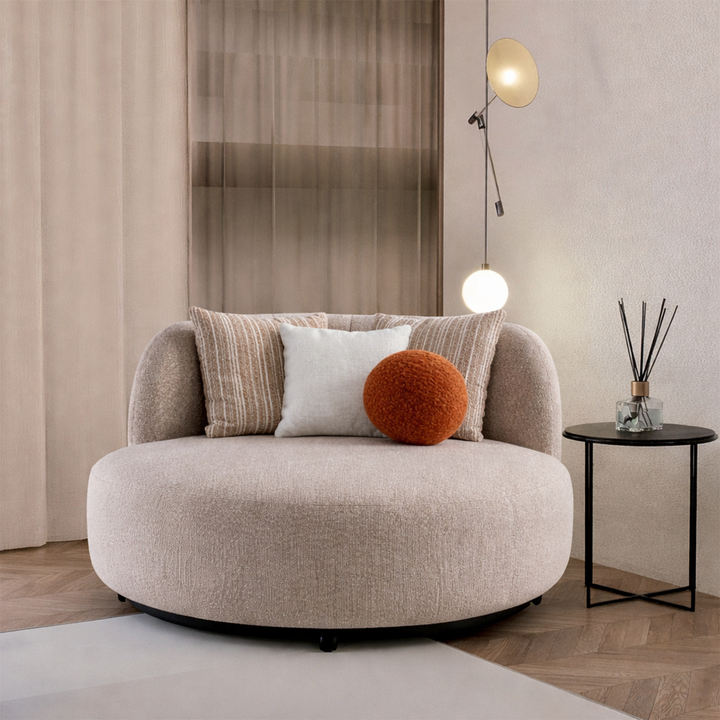 Modern beige armchair with decorative pillows in a stylish room.