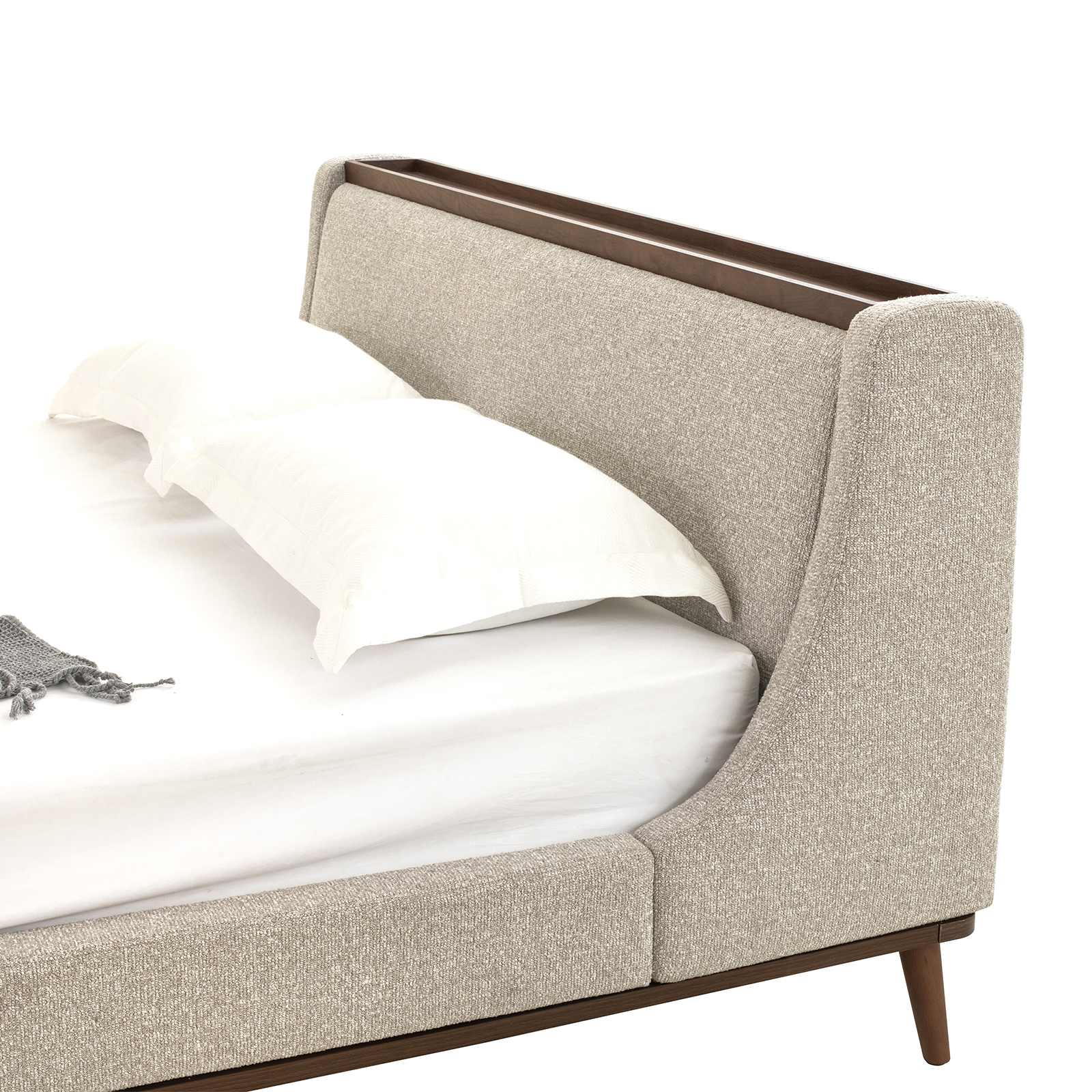 Beige upholstered bed with wooden frame on a white background