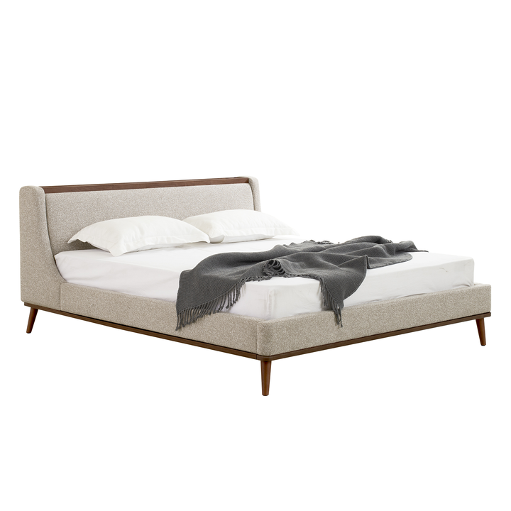 Bed with beige upholstered headboard and wooden legs on a white background