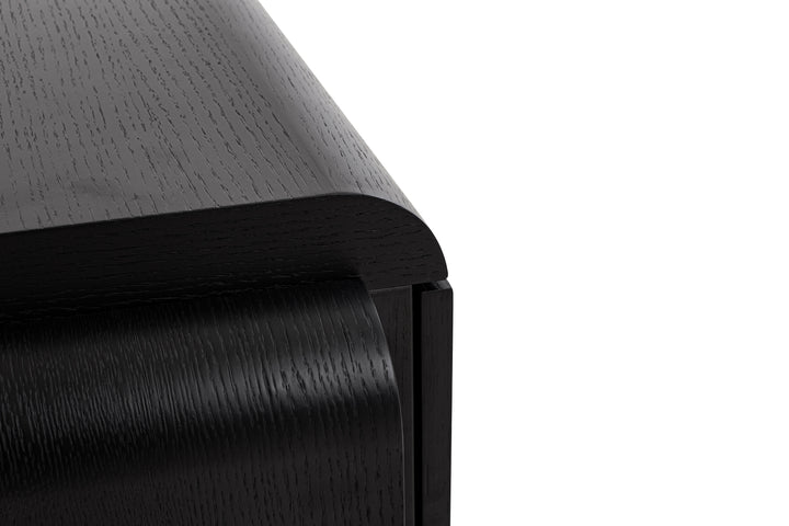 Close-up of a black rubber door stopper on a white background