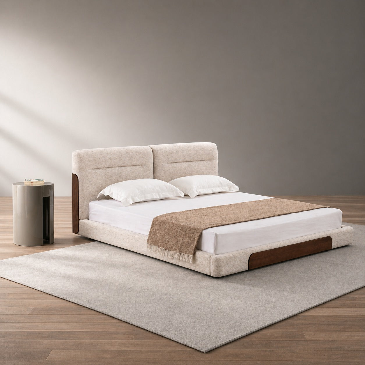 Beige upholstered bed with wooden legs in a minimalistic room.