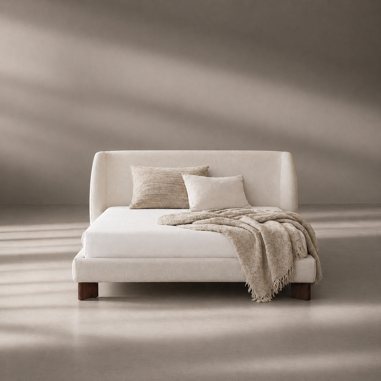 White bed with beige pillows and blanket in a minimalistic room