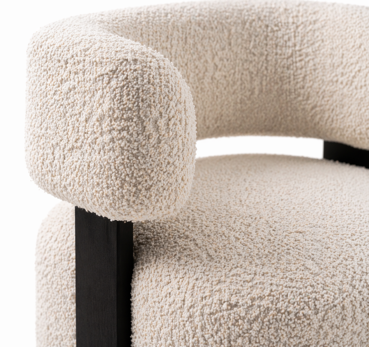 Close-up of a textured beige chair with a black leg.