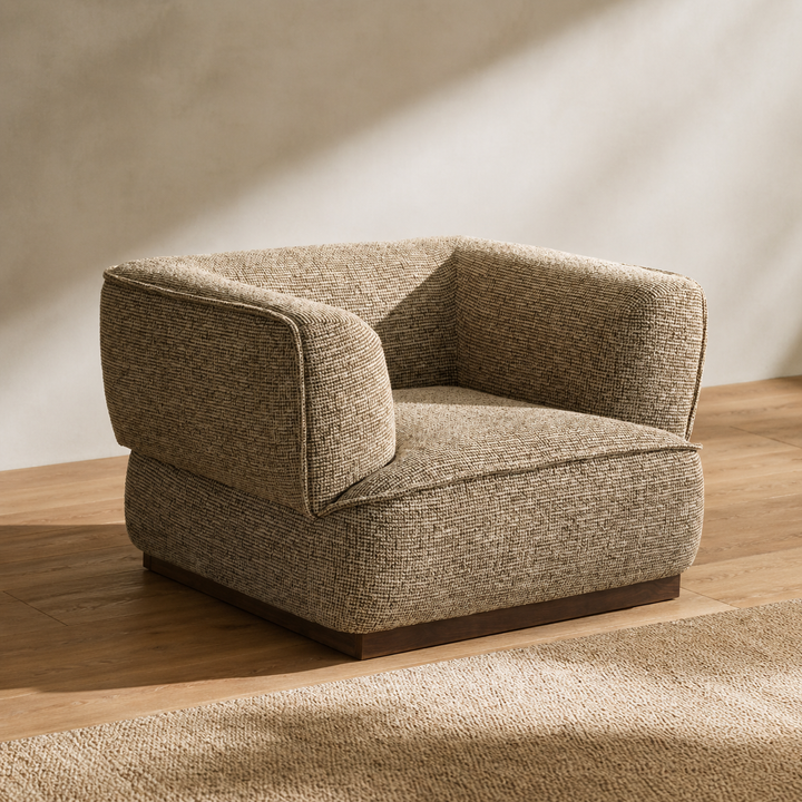 Beige armchair on a wooden floor with a neutral wall background
