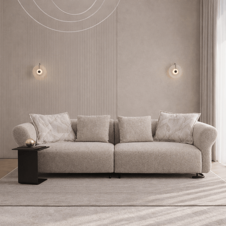 Beige sofa with decorative pillows in a modern living room setting.