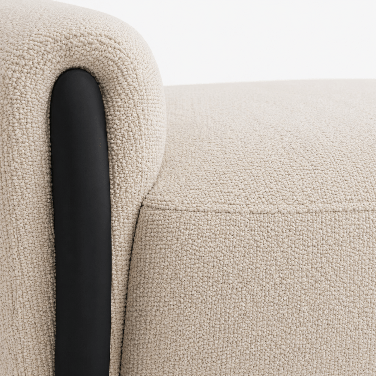 Close-up of a textured beige sofa with a black armrest.