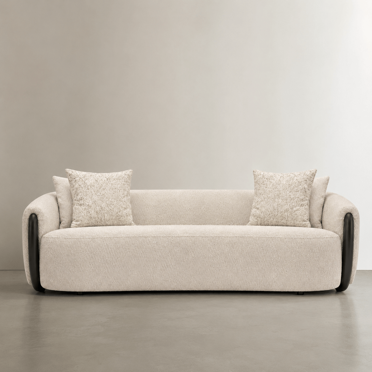 Beige sofa with two cushions on a neutral background