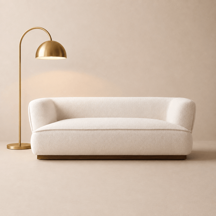 Beige sofa with a gold floor lamp against a beige wall