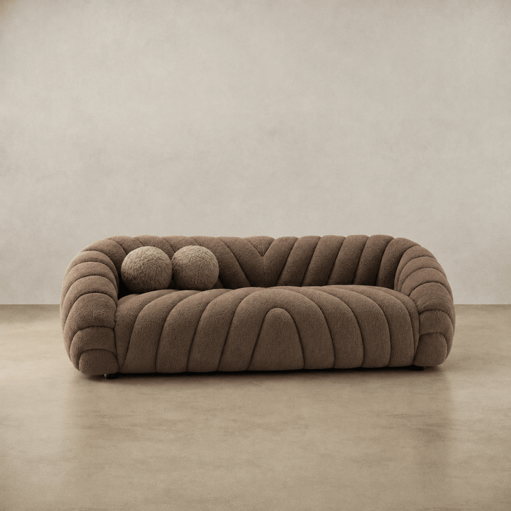 Brown textured sofa on a beige floor with a neutral wall background