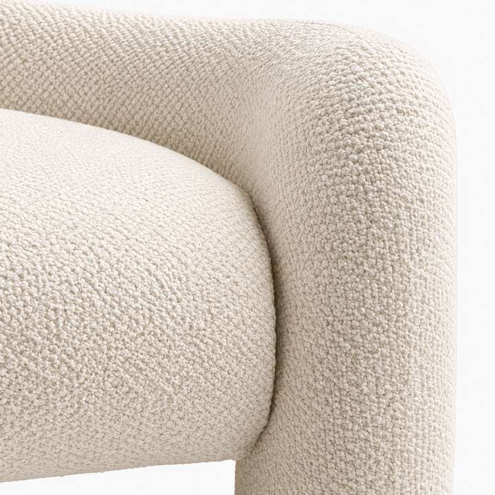 Close-up of a textured beige armchair corner on a white background