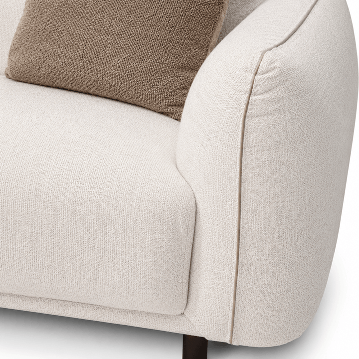 Close-up of a beige armchair with a brown cushion on a white background