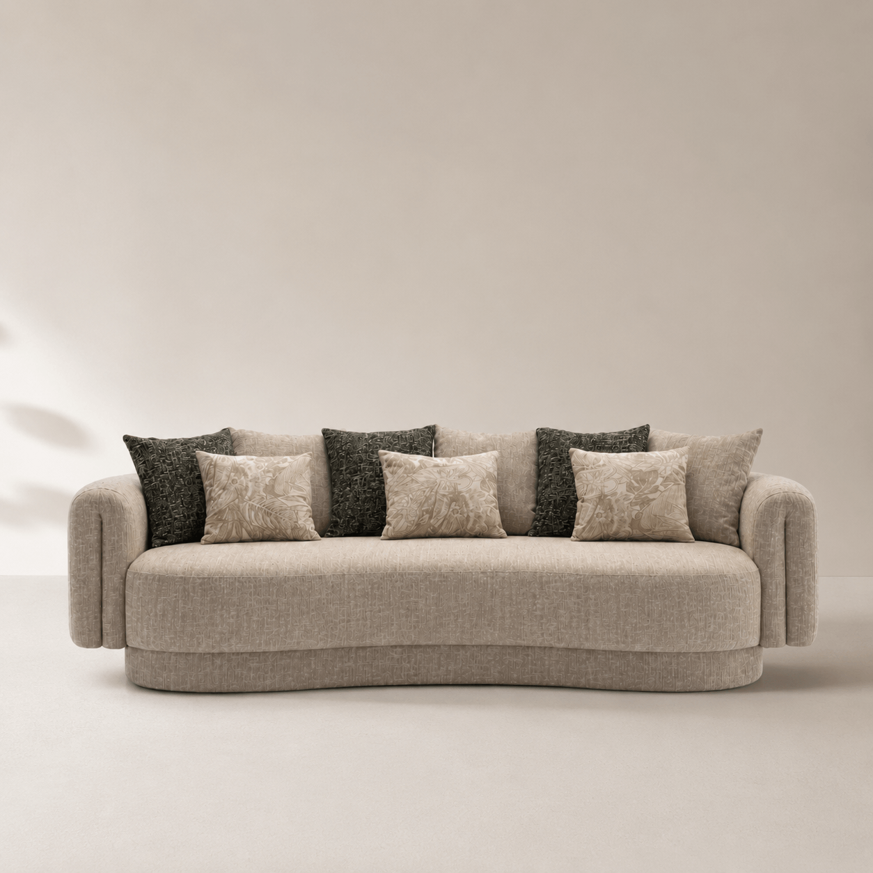 Beige sofa with patterned cushions against a plain background
