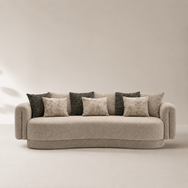 Beige sofa with patterned cushions against a plain background