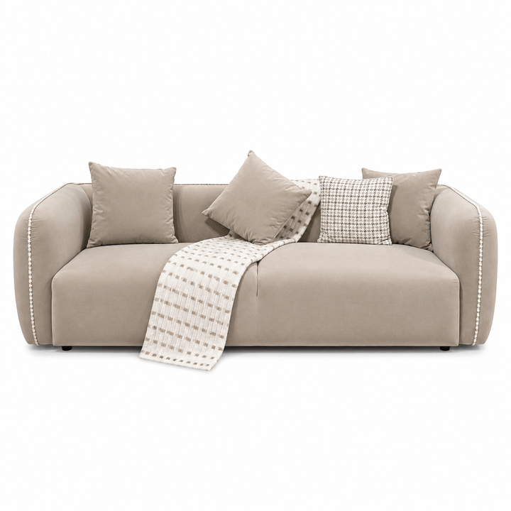 Beige sofa with cushions and a blanket on a white background