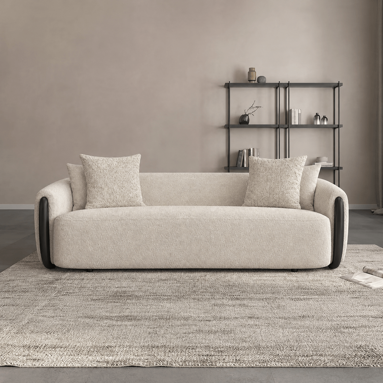 Beige sofa with cushions in a room with a bookshelf and rug.