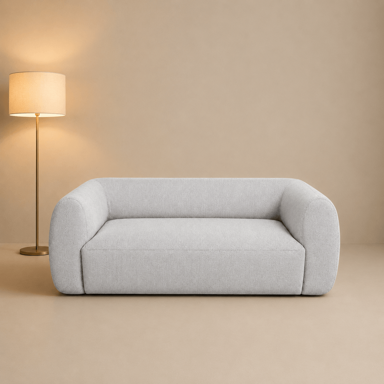 Light gray sofa in a room with a beige wall and floor, and a standing lamp.