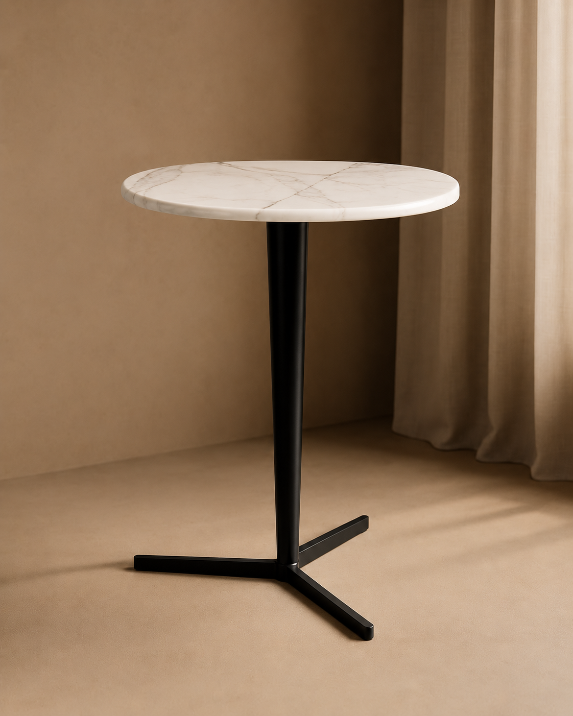 Round marble table with black metal base against a beige wall