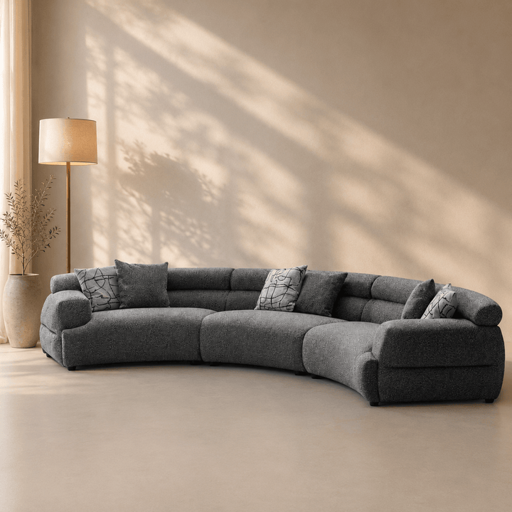 Gray sectional sofa in a room with a lamp and decorative items.