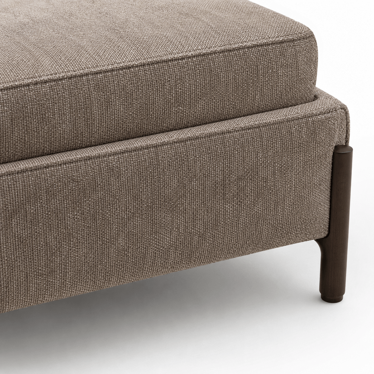Brown upholstered ottoman with a wooden leg on a white background