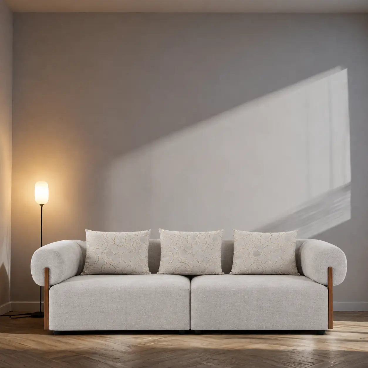 Light gray sofa with wooden legs in a minimalistic room with a lamp and abstract painting.