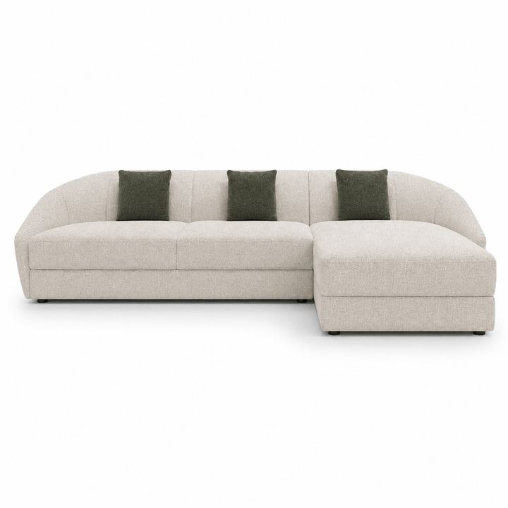 Beige sectional sofa with green cushions on a white background