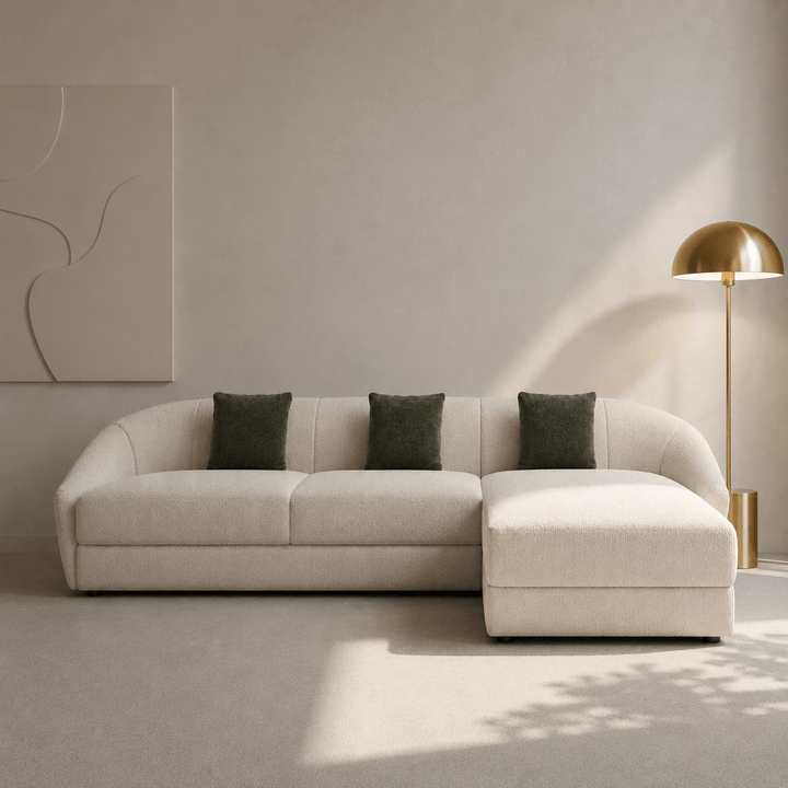 Beige sectional sofa with gray cushions in a modern living room setting.