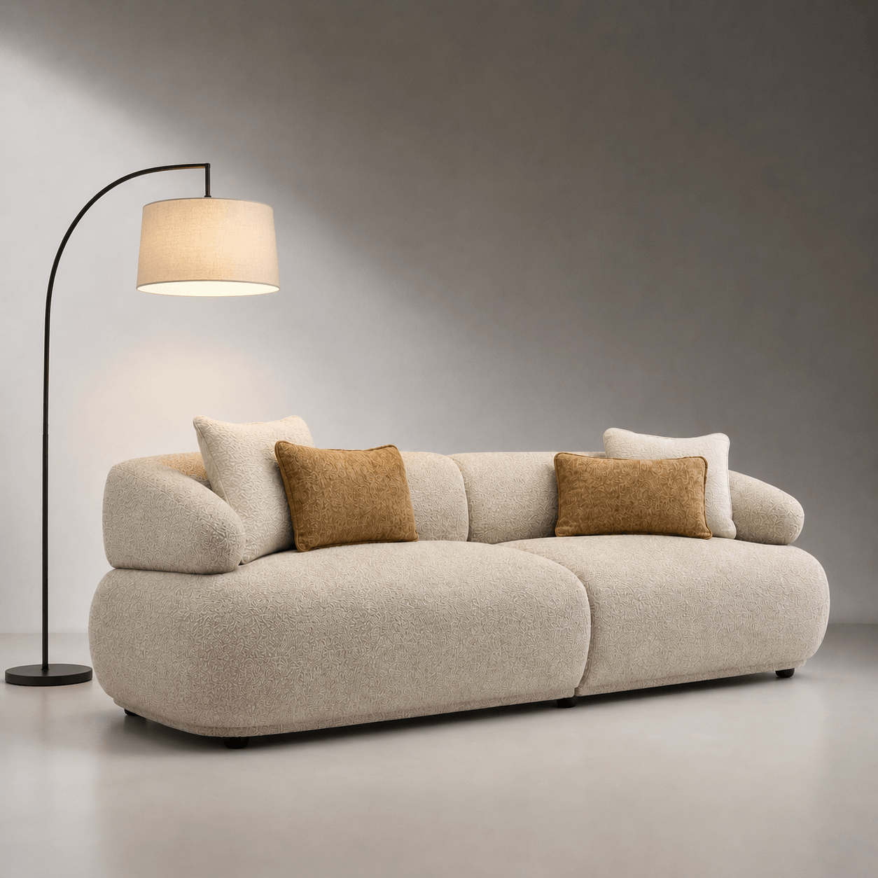 Beige sofa with decorative pillows in a minimalistic room with a floor lamp.