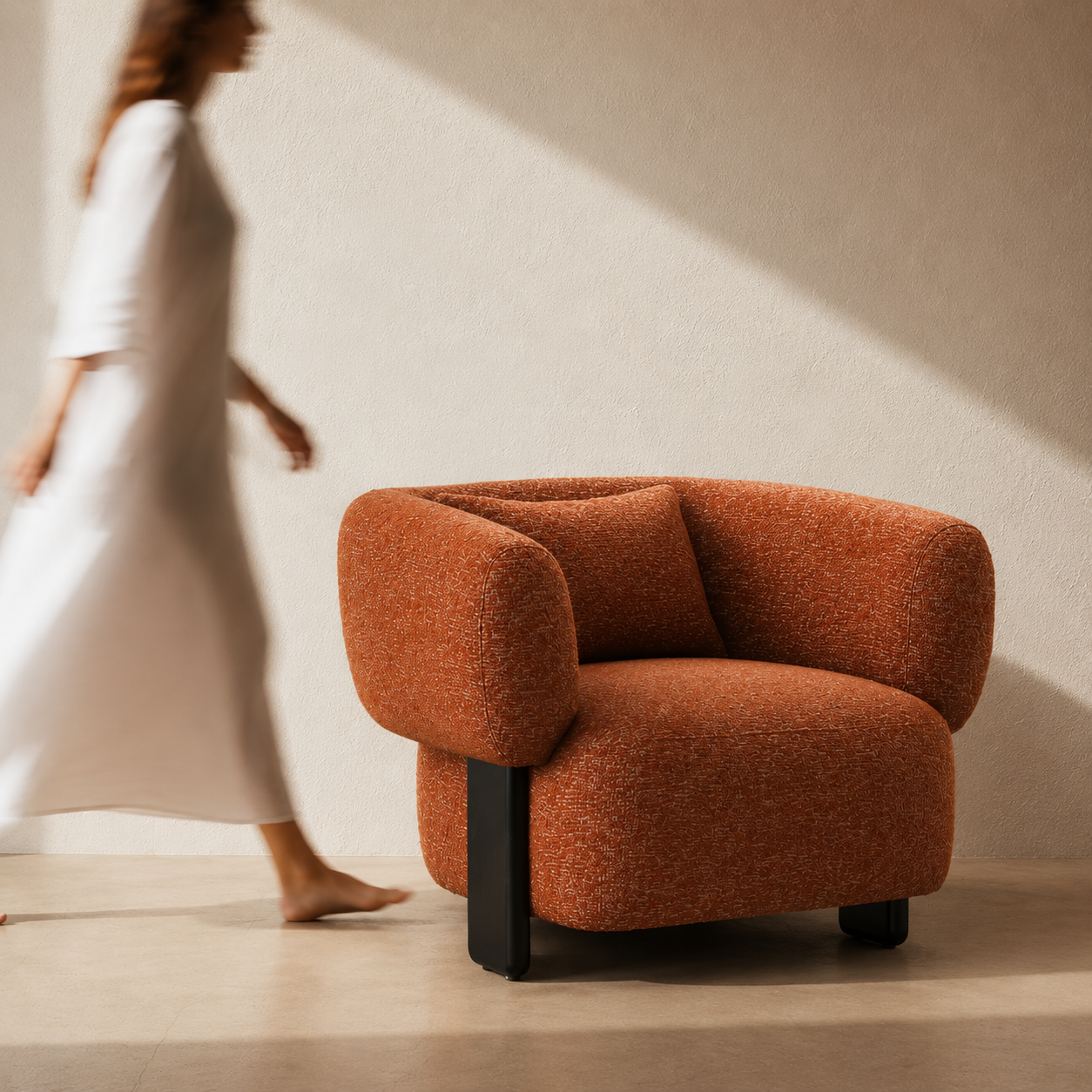 Orange armchair in a room with a person partially visible in the background