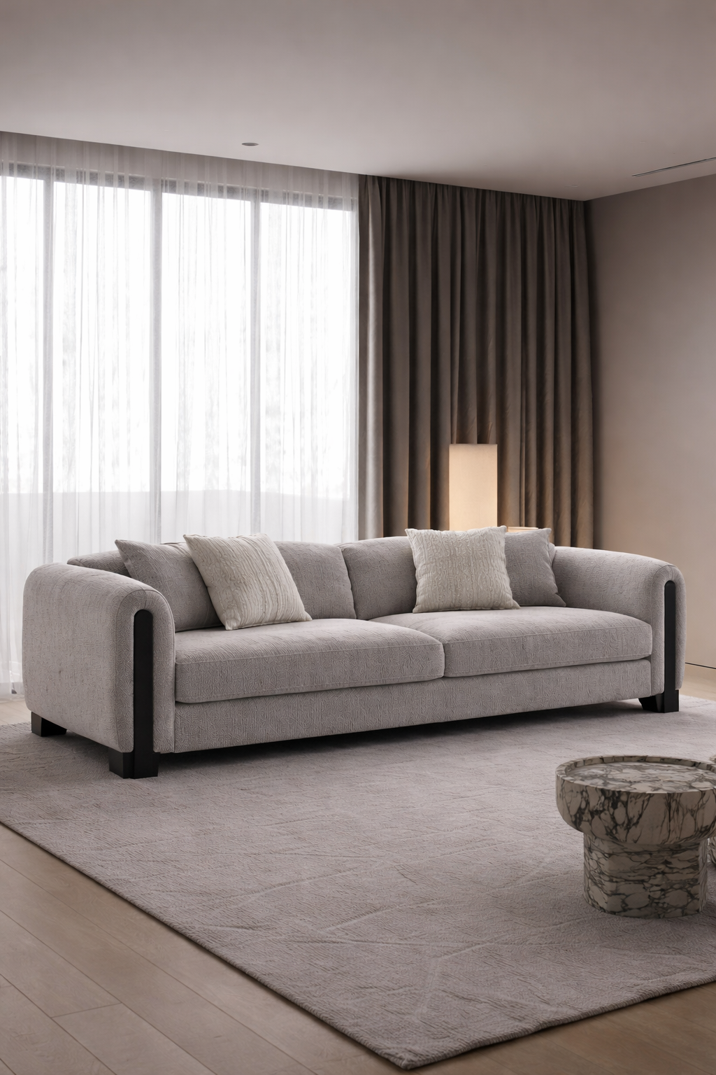 Gray sofa in a modern living room with a coffee table and large windows.