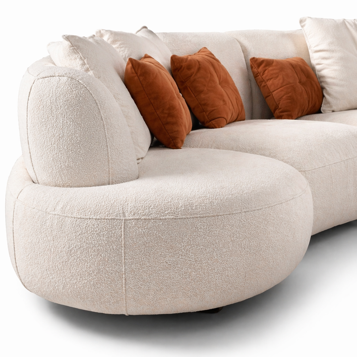 Beige sectional sofa with brown cushions on a white background