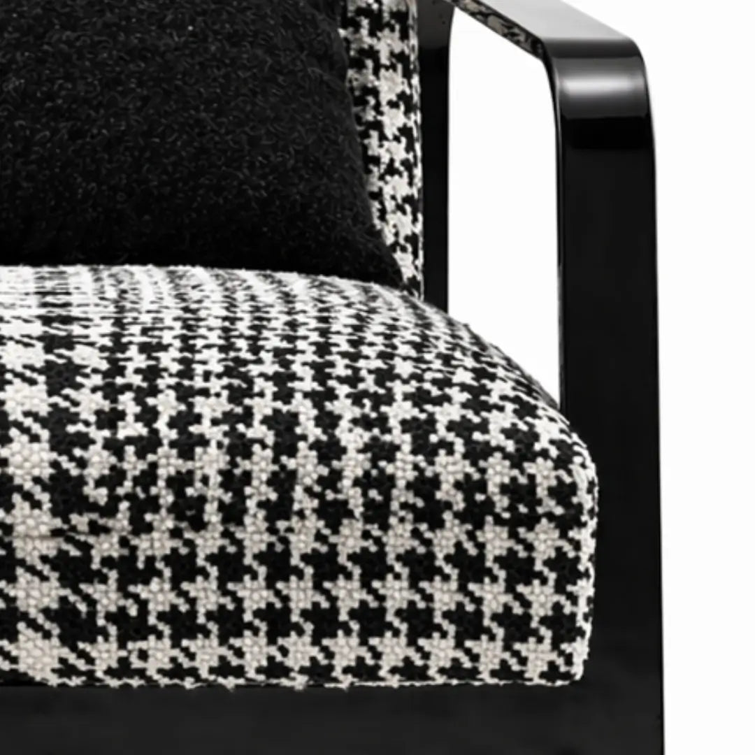 Close-up of a chair with black and white houndstooth patterned seat and backrest.